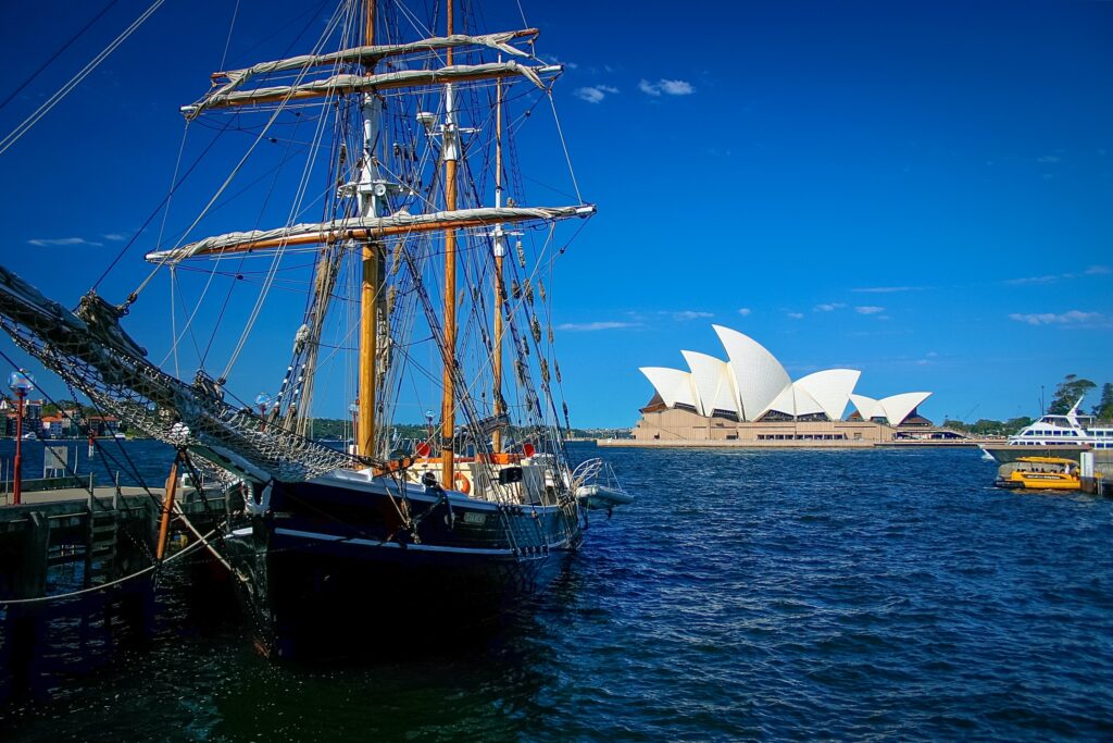 brown and black sailboat near Sydney Opera House