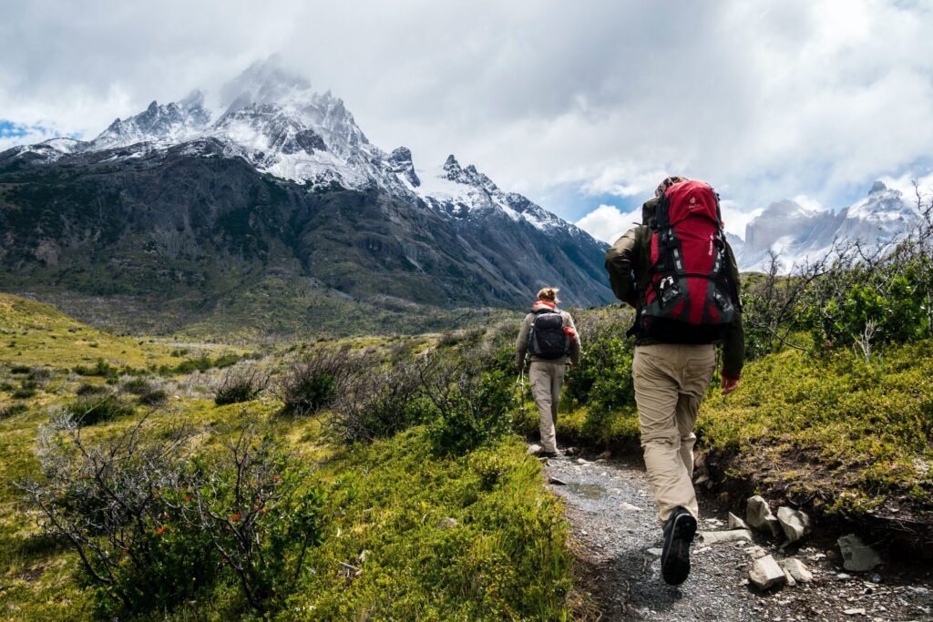 two person walking towards mountain covered with snow. The Best hiking trails near me