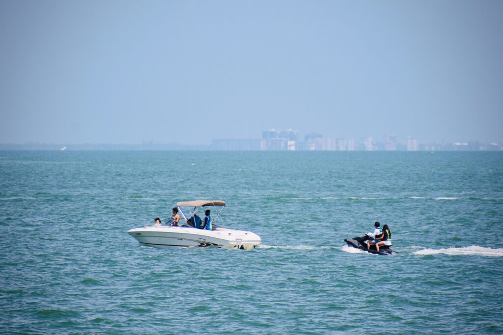 a group of people riding on the back of a white boat and Jet Ski Boat Rental in Miami